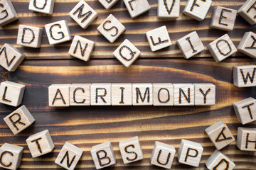 acrimony wooden cubes with letters, bitter full of anger concept, around the cubes random letters, top view on wooden background