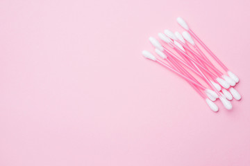Pink cotton buds on pink background. Selective focus Copy space.