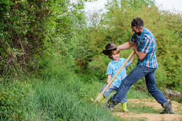 Fototapeta premium small boy child help father in farming. new life. soils and fertilizers. rich natural soil. Eco farm. Ranch. father and son planting family tree. happy earth day. Dig grounf with shovel. New flowers