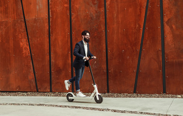 Cheerful businessman riding electric scooter