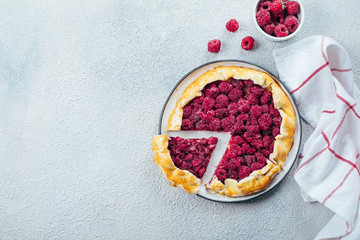 Homemade raspberry open pie gallete on a light concrete table background. Top view, copy space