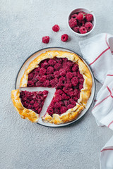 Homemade raspberry open pie gallete with on a light concrete table background. Top view