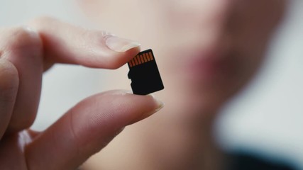 Tiny micro sd card storage held in hand, close up shot
