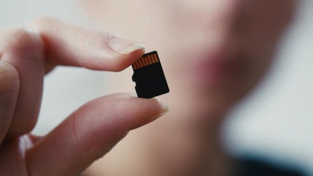 Tiny micro sd card storage held in hand, close up shot