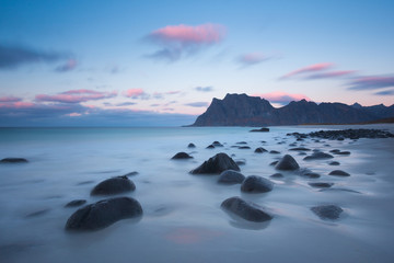 Rocky shore of Uttakleiv beach in fall, Vestvagoy, Lofoten Islands, Norway 
Rocks on beach of fjord of Norwegian sea in autumn with colorful clouds