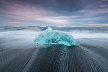 Dramatic weather over famous Diamond beach, Iceland. This sand lava beach is full of many giant ice gems, places near glacier lagoon Jokulsarlon Ice rock with black sand beach in southeast Iceland