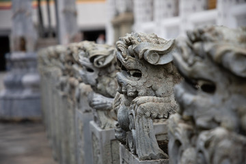 Fototapeta na wymiar Close up of aligned stone animal statues from a temple at Bangkok