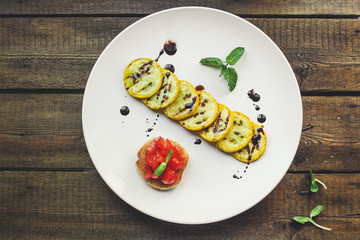 grilled zucchini and bruschetta with tomato (snack or snack salad). top food background. copy space