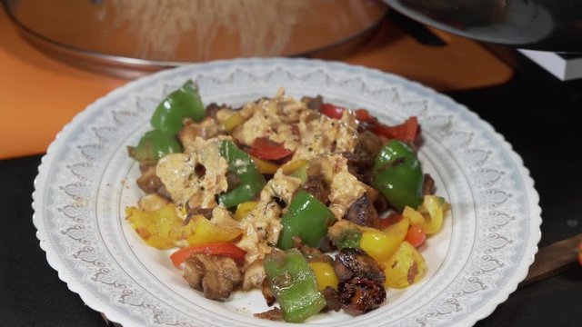The process of adding gravy to mushroom saute.Green, red and yellow bell pappers at a background