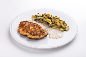 pork schnitzel with fried potatoes and mushrooms and white sauce isolated on white background