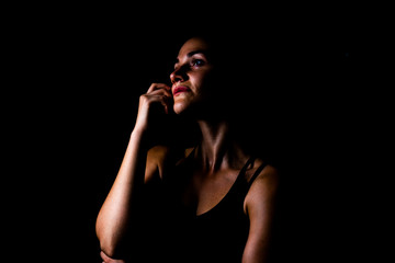 Girl in sport wear wonder position isolated with black background low key shot