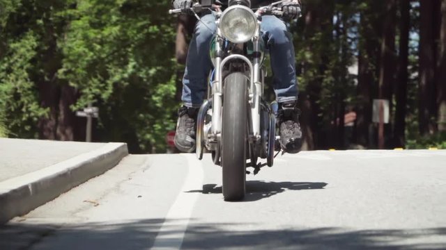 Slow Motion of Motorcyclist With Leather Jacket Coming to a Stop on a Wooded Road