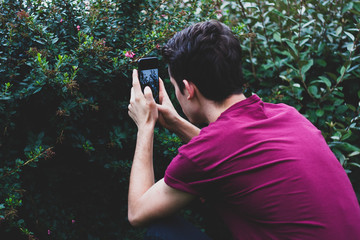 Man taking picture of flowers with a phone