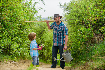 Tree planting tradition. Little helper in garden. Planting flowers. Growing plants. Boy and father in nature with watering can and shovel. Dad teaching son care plants. Arbor day. Planting trees © be free