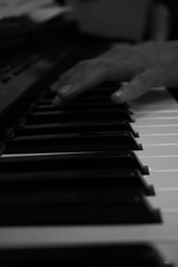 Fototapeta na wymiar Hand playing piano perspective in black and white
