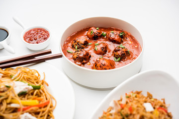 Assorted Indo chinese food in group includes non vegetarian or chicken Schezwan/Szechuan hakka noodles, fried rice, manchurian, egg american chop suey, soup with spoon and chop sticks, selective focus