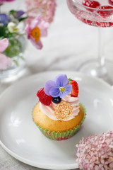 Cupcake decorated with buttercream, fruits and flowers