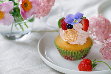 Cupcake decorated with buttercream, fruits and flowers