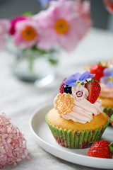 Cupcake decorated with buttercream, fruits and flowers