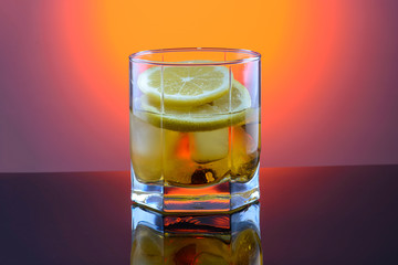 whiskey in a glass with ice and lemon