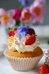 Cupcake decorated with buttercream, fruits and flowers