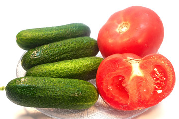 Cucumbers with tomatoes in a plate on a white background