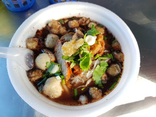 Close up of a bowl of Thai style pork noodle soup.