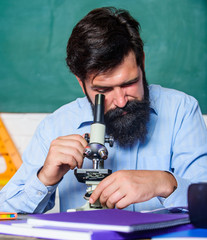 Set up microscope. Teacher sit desk with microscope. Man bearded hipster classroom chalkboard...