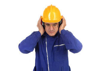 Worker covering his ears with yellow helmet