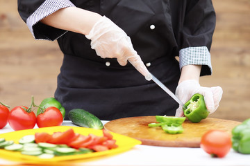 The cook cuts fresh farm vegetables