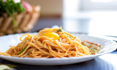 Delicious pasta with egg yolk, on wooden table.