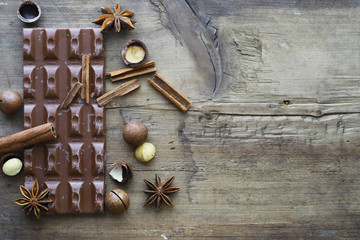 A bar of milk chocolate on the table. Chocolate with nuts and cinnamon.