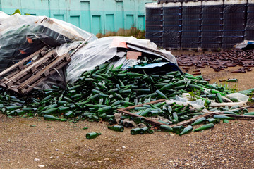abandoned glass factory. packed bottles in pallets, broken bottles on asphalt, lots of loose...