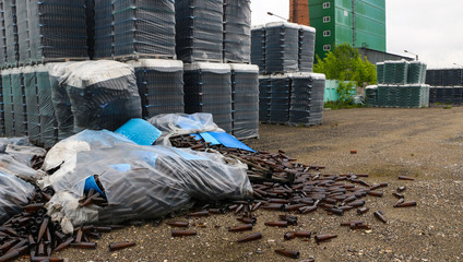 abandoned glass factory. packed bottles in pallets, broken bottles on asphalt, lots of loose bottles and garbage from production. devastation, separation, bankruptcy of  enterprise.