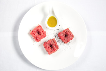 Flat lay of raw meat with oil and pepper
