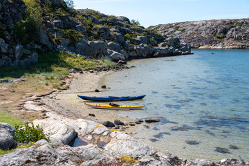 View of two kayaks lying on the shore of a bay on the archipelago coast of western Sweden.