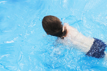 boy swims in the pool. boy learning to swim in the pool