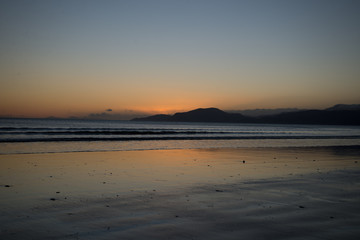 sunset on beach. Mountain background