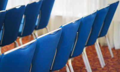 Blue empty seats in the audience prepared for the participants of the conference or presentation. 