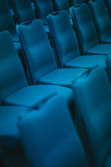 Blue empty seats in the audience prepared for the participants of the conference or presentation. 