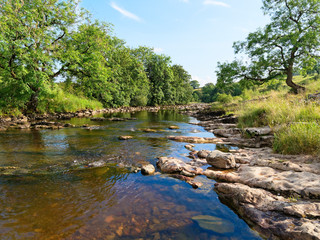 Gently flowing River Ribble near Little Stainforth in Yorkshire on a summer afternoon.