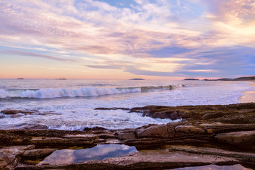 The stony coast of the Atlantic Ocean in the evening light. Deserted beautiful beach. USA. Maine.