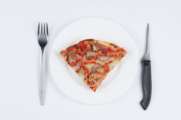 A delicious homemade pizza on a plate isolated on a white background. Pizza on a plate with a knife and a fork