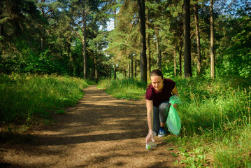 Woman collecting garbage in forest