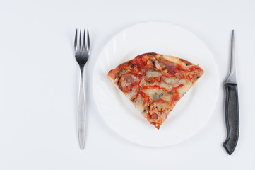 A delicious homemade pizza on a plate isolated on a white background. Pizza on a plate with a knife and a fork