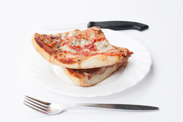 A delicious homemade pizza on a plate isolated on a white background. Pizza on a plate with a knife and a fork