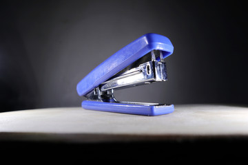 blue stapler and dark background
