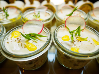 A number of portion salads decorated with a slice of radish and greens.