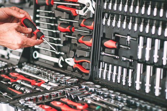 Hardware showcase. Cropped shot of repairman choosing screwdriver in tool store.