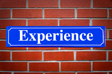 Experience street sign on brick wall